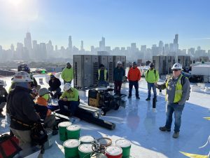 Combined Roofing workers standing on a roof with the chicago skyline in the background